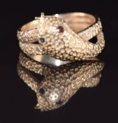 A 9ct gold ring in the form of a snake with textured surface set with garnet eyes, 5.3g, K/L