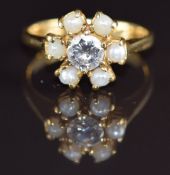 An 18ct gold ring set with a round cut diamond of approximately 0.5ct surrounded by pearls, 4.7g,