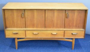 G Plan mid century modern teak sideboard with pivoting sliding doors and three straight drawers,
