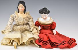 Two Victorian porcelain dolls with straw stuffed bodies, one with elaborate moulded hairstyle and