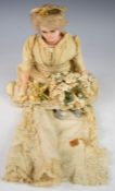 A wax over composition doll dressed in a bridal gown, with stuffed cloth body, blue glass eyes,