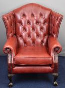 Thomas Lloyd red leather Chesterfield chair raised on ball and claw feet, with Thomas Lloyd