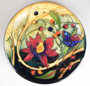 Moorcroft pottery wall plaque with decoration of butterfly and ladybird amongst flowers, diameter