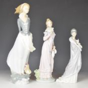Three Lladro and Nao figures comprising Lladro girl holding book behind her, height 36cm, Lladro