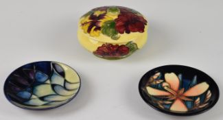 Moorcroft pottery pedestal covered pot decorated in the Hibiscus pattern and two Moorcroft pin