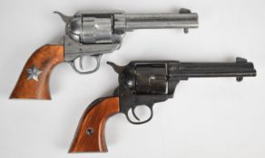 Two Colt Single Action Army .45 style six shot single action revolvers, both with shaped wooden