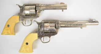 A near pair of Colt style six shot single action revolvers, each with ornate decoration to the