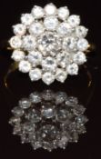 An 18ct gold ring set with a cluster of round cut diamonds, the centre diamond approximately 0.44ct,