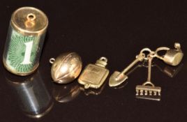 Four 9ct gold charms comprising one set with a 1 shilling note (3.2g), a hot water bottle, rugby