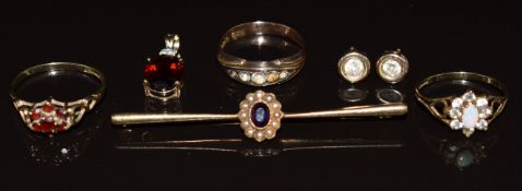 Three 9ct gold rings, one set with opal and cubic zirconia, one with garnets and the other paste,
