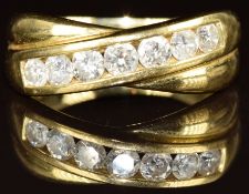 An 18ct gold ring set with seven round cut diamonds graduating from 0.08ct to 0.12ct in a cross over