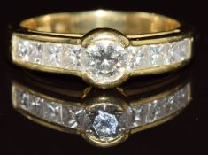 An 18ct gold ring set with a round cut diamond and eight princess cut diamonds, the largest