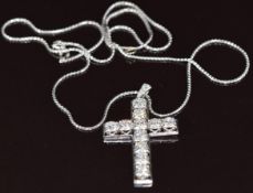 An 18ct white gold cross pendant set with eleven round brilliant cut diamonds and two European cut
