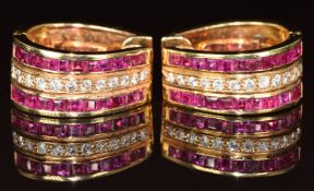 A pair of 18k gold earrings set with a row of diamonds and two rows of calibre cut rubies, the total