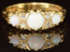 An 18ct gold ring set with three round cut opal cabochons and diamonds, 5.4g, size N