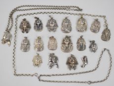 Seventeen silver Egyptian pendants in the form of pharaohs and three silver chains, 198g