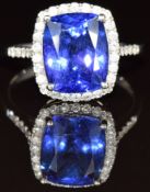 A platinum ring set with a cushion cut tanzanite of approximately 4ct surrounded by diamonds, with