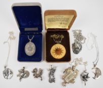 A collection of silver pendants including four pendants in the form of dragons, one in the form of a
