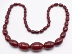 Cherry amber necklace made up of forty one graduated oval beads, largest 17 x 25mm, smallest 7 x