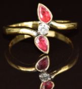An 18ct gold ring set with a diamond of approximately 0.1ct and two pear cut rubies, 4.3g, size P