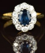 An 18ct gold ring set with an oval cut sapphire of approximately 0.8ct surrounded by ten diamonds,