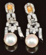A pair of white metal sections of earrings each set with round and baguette cut diamonds and a