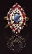 An 18ct gold ring set with garnets in a marquise shaped setting, 5.2g, size L