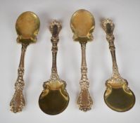Set of four American silver spoons with decorative handles and gilt bowls, marked sterling and