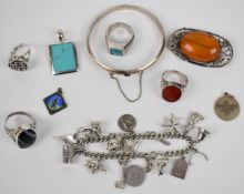 A collection of silver jewellery including charm bracelet, bangle, two rings set with agate, ring