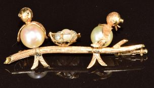 A 15ct gold brooch in the form of two birds and nest, set with pearls as the bodies of the birds and