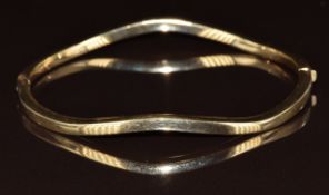 A 9ct gold bangle in a wave design, 5.7g, 5 x 6cm