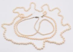 Three single strands of cultured pearls, one with a 9ct white gold clasp set with a diamond (one