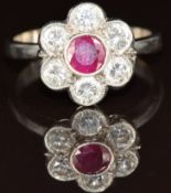 An 18ct white gold ring set with a round cut ruby of approximately 0.32ct surrounded by six round
