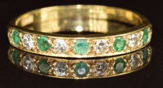 An 18ct gold half eternity ring set with round cut emeralds and diamonds, 2.3g, size P