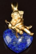 Charles Garnier 18ct gold pendant depicting a cherub sitting on a lapis lazuli heart, 11.4g, 4.5cm
