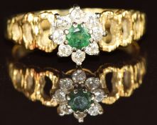 An 18ct gold ring set with an emerald surrounded by diamonds, with pierced shoulders, 3.4g, size M