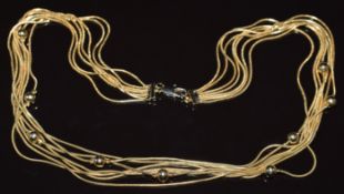 A yellow metal seven strand necklace made up of snake chains and sphere beads, 20.6g, 40cm