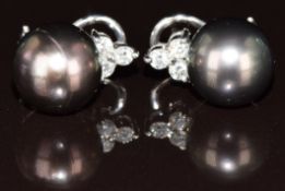 A pair of 14k white gold earrings each set with a Tahitian pearl and three diamonds, 8.8g