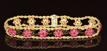 A 14k gold bracelet set with clusters of rubies between rope twist borders, 12.5g, 17cm