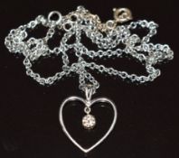 An 18k white gold heart pendant set with a round cut diamond of approximately 0.15ct, on 18k white