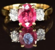 An 18ct gold ring set with an oval cut ruby of approximately 2ct and two oval cut diamonds of