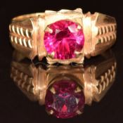 An 18k gold ring set with a round cut synthetic ruby, 3.9g, size O