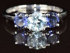 A 9k white gold ring set with a round cut aquamarine and two iolite, 1.9g, size Q