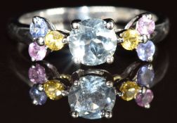 A 9k white gold ring set with a round cut aquamarine, yellow sapphires, pink sapphires and