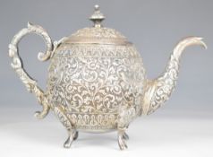Indian Kutch silver bachelor's teapot with embossed decoration of birds amongst foliage, length 17.