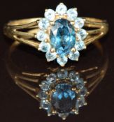 A 9k gold ring set with an oval cut topaz surrounded by further topaz, 1.8g, size P
