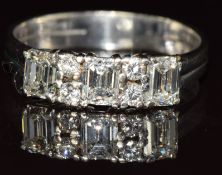 A 14k white gold ring set with three emerald cut diamonds of 0.4ct, 0.35ct and 0.35ct and four