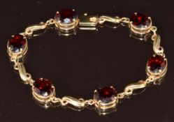 A 9ct gold bracelet set with oval cut garnets, 14.2g, 18cm