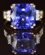 An 18ct gold ring set with a cushion cut tanzanite of approximately 7.85ct with round and baguette