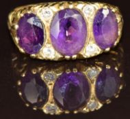 An 18ct gold ring set with three oval cut amethysts and diamonds, 6.5g, size L